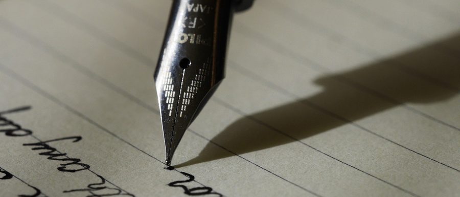 Une plume traçant des lignes sur un manuscrit