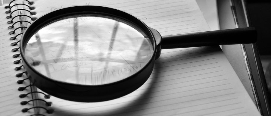 Une loupe posée sur des documents de travail